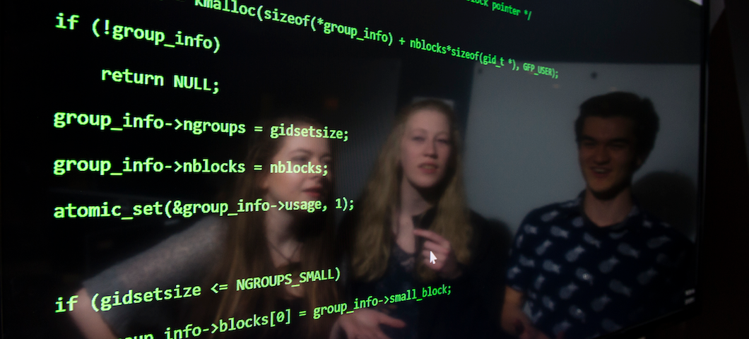 three computer science students reflected on computer screen